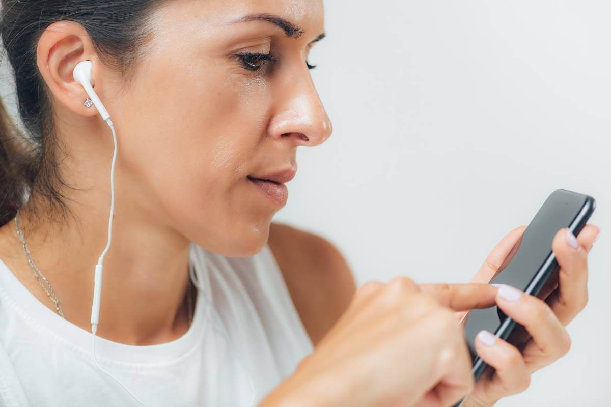 woman using her phone to self administer a hearing test