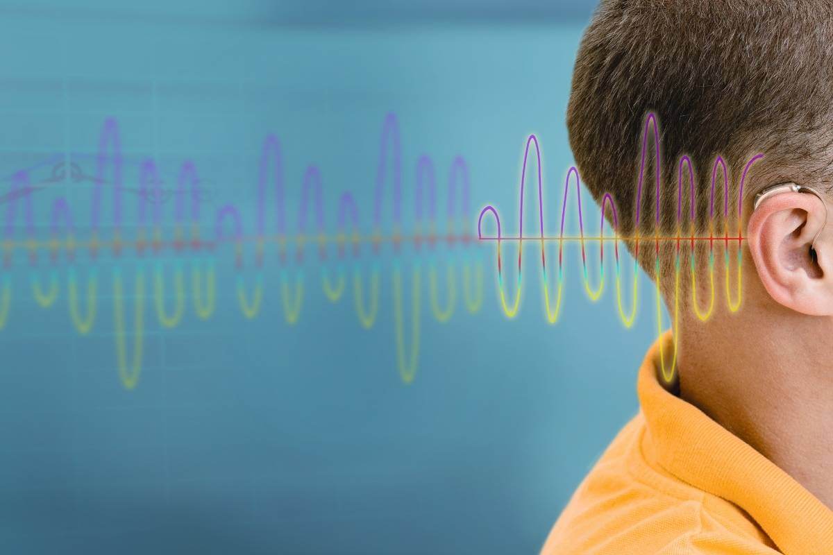 young kid with hearing aid next to a frequency overlay